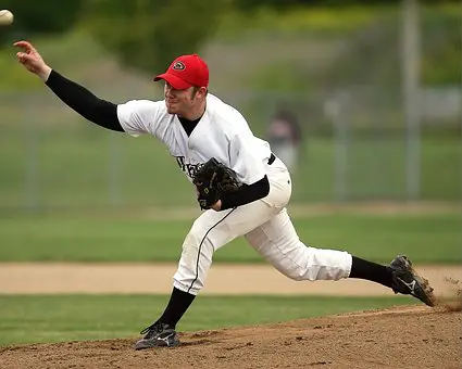 A baseball player is throwing the ball on the field.